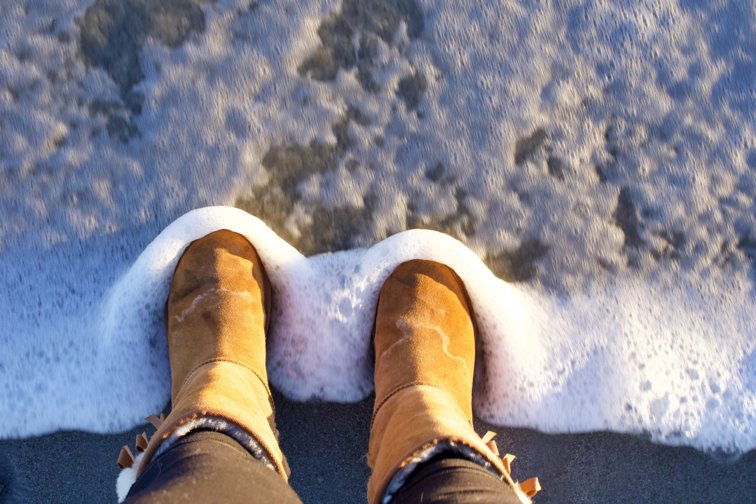 person in brown winter boots standing on snow covered ground